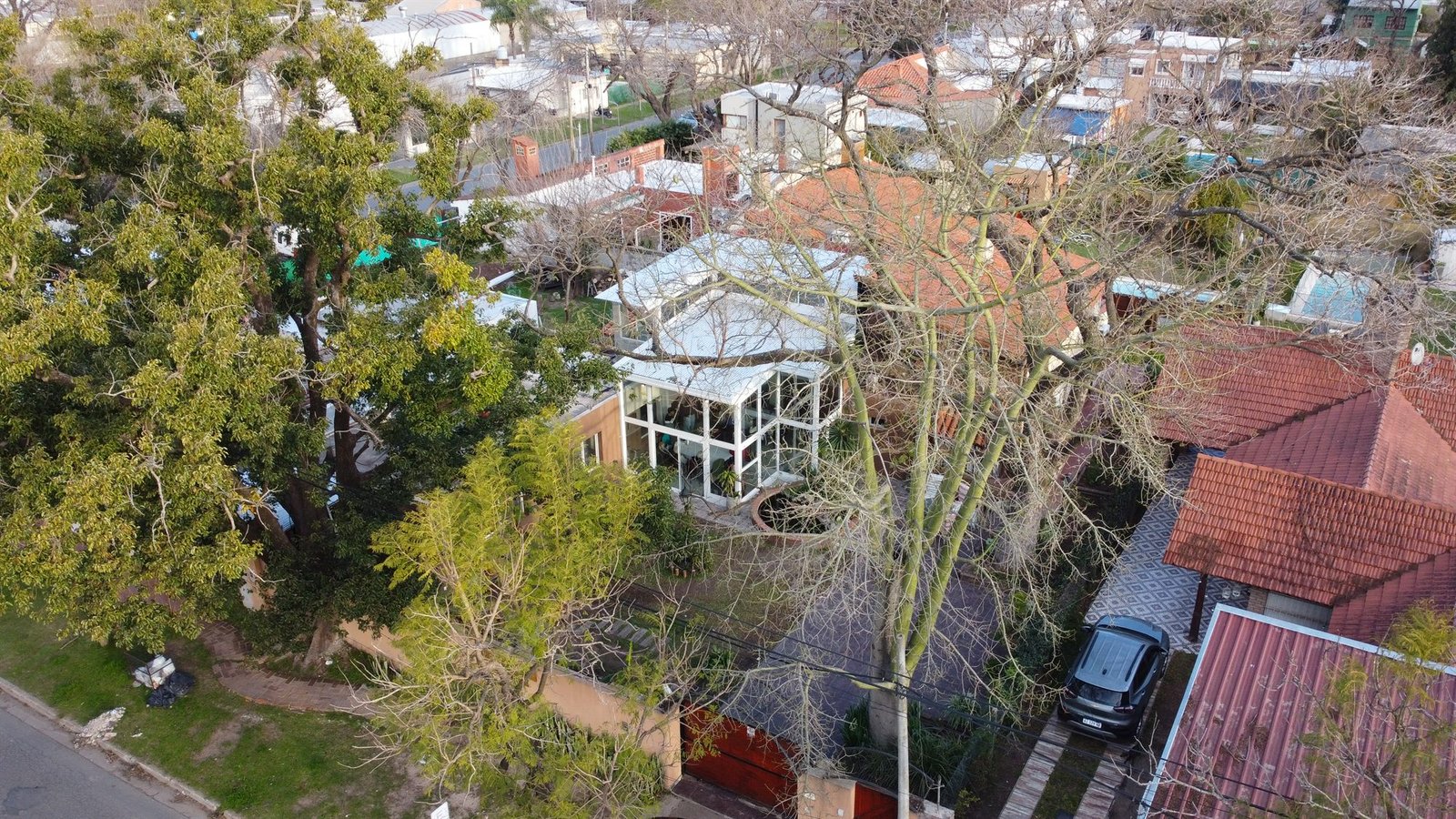 Vista aérea de la casa de Alcanfor rodeada de arboleda en Funes.