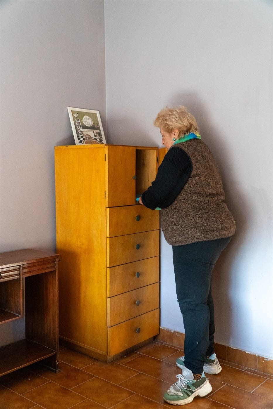 Una residente acomoda sus pertenencias en su habitación.